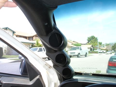1993 Ford Taurus - A black gauge pod is mounted on the A-pillar, obscuring the view of a suburban street with several vehicles.