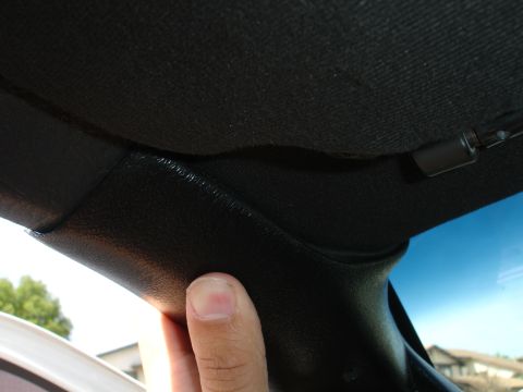 1993 Ford Taurus - Close-up view of the interior pillar trim and headliner of a vehicle.