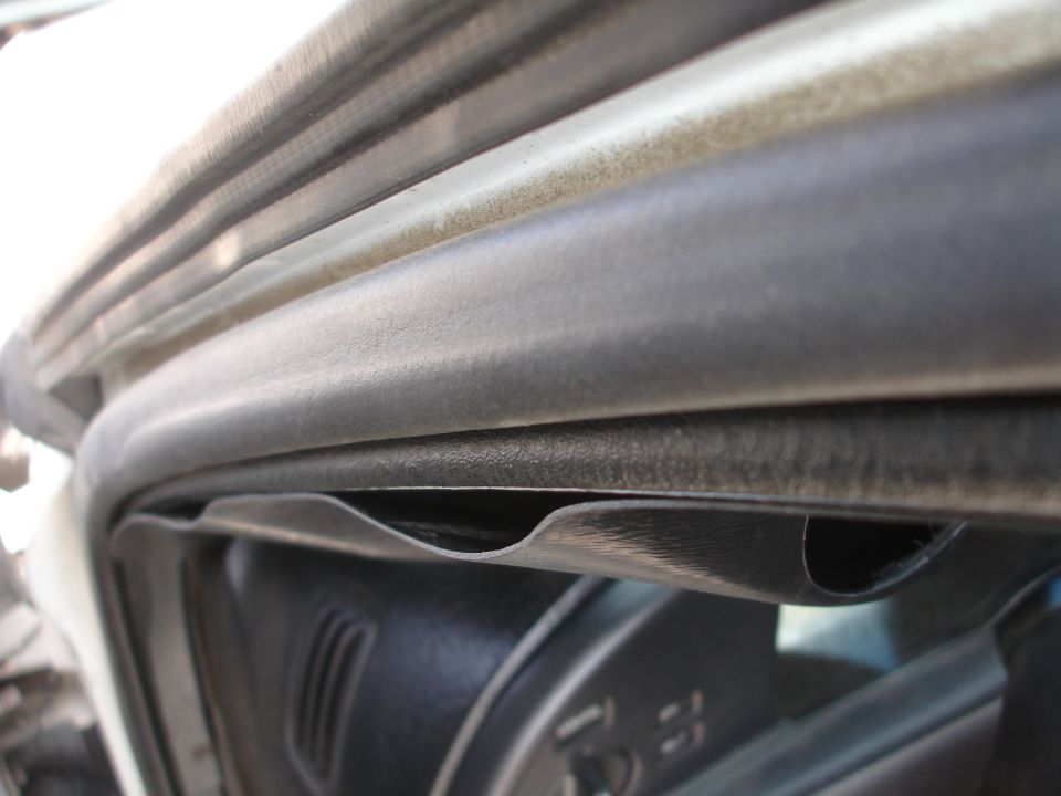 Car door seal and interior panel detail, close-up view