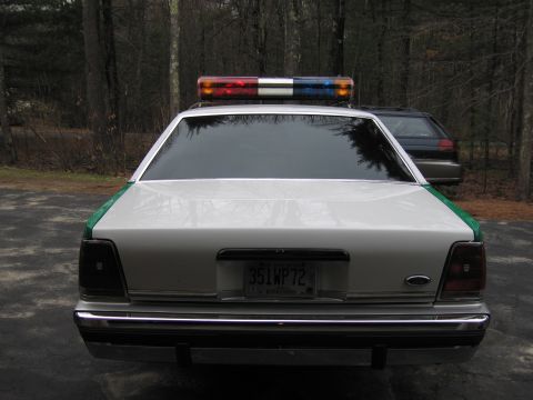 1991 Ford LTD Crown Victoria - Rear view of a green and white Ford sedan with roof light bar and a New Hampshire 351WP72 plate, parked on a driveway.