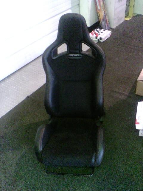 2001 Ford Crown Victoria - A black Recaro racing seat is shown, harness cutouts and the brand name visible on the headrest.