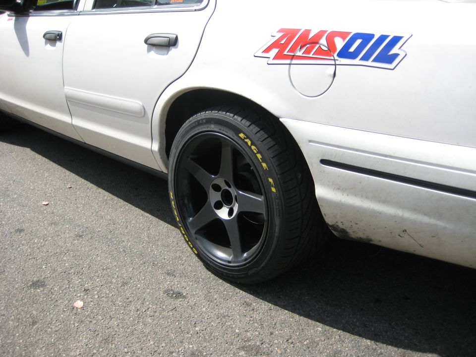 White sedan with black five-spoke wheels and an Amsoil decal on the rear quarter panel