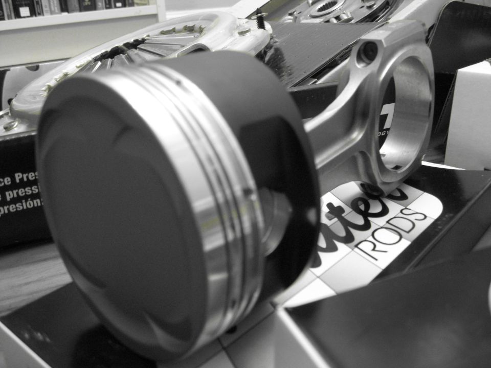 Piston and connecting rod assembly on a box labeled "RODS"
