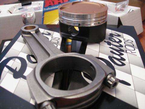 1994 Ford Probe - A connecting rod and piston are displayed on a box, with text indicating 'auter RODS' and 'SUPERMOTORS.NET'.