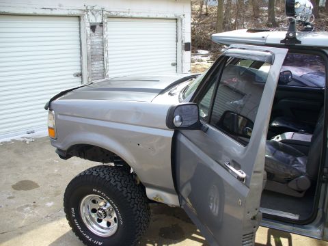 1994 Ford Bronco - This Ford F-150 pickup truck has a lifted suspension and off-road tires. The driver's door is open, revealing the interior.