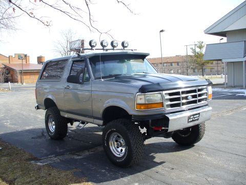 1994 Ford Bronco - This lifted Ford Bronco has a chrome bumper and four lights mounted on its roof rack.