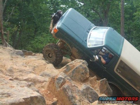 1990 Ford Bronco - This vehicle is navigating a challenging off-road course with large rocks.