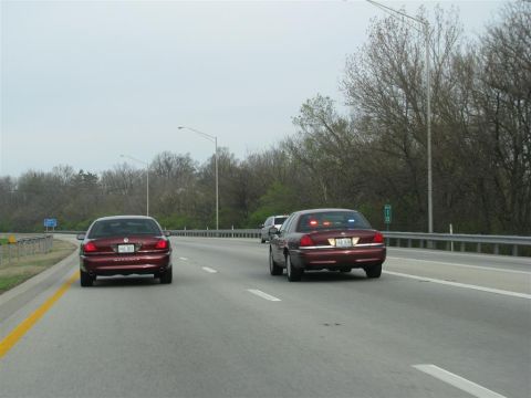 2003 Mercury Marauder - Two maroon 2003 Mercury Marauders are seen driving on a highway, with one vehicle displaying flashing lights.