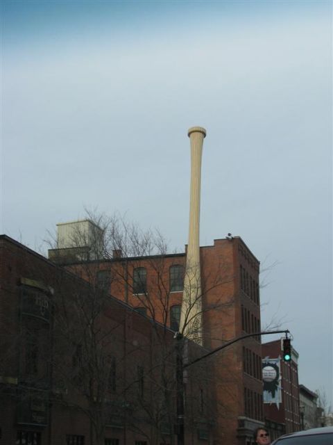 2003 Mercury Marauder - An industrial chimney stands tall against a backdrop of brick buildings and an overcast sky.