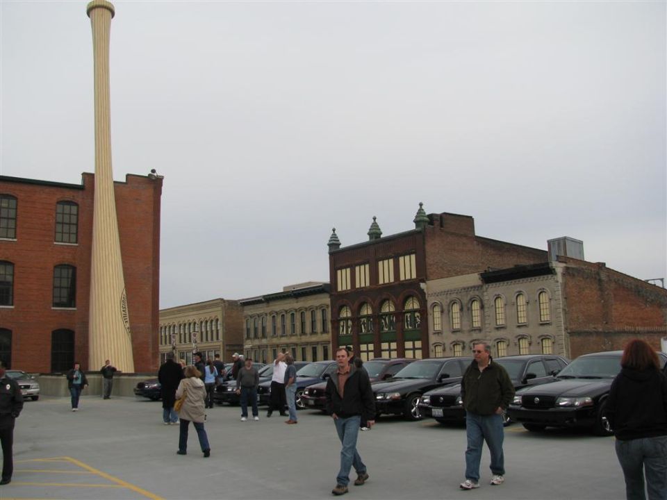 Several black 2003 Mercury Marauders parked in a lot with a giant baseball bat sculpture