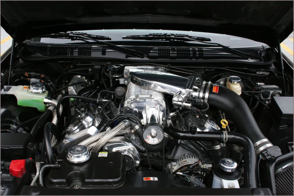 Engine bay with polished supercharger under an open hood