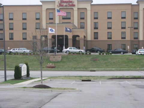 2003 Mercury Marauder - Multiple sedans are parked on a grassy incline in front of a hotel building.