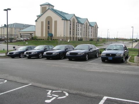 2003 Mercury Marauder - A group of five dark Mercury Marauders are parked in a lot in front of a hotel.
