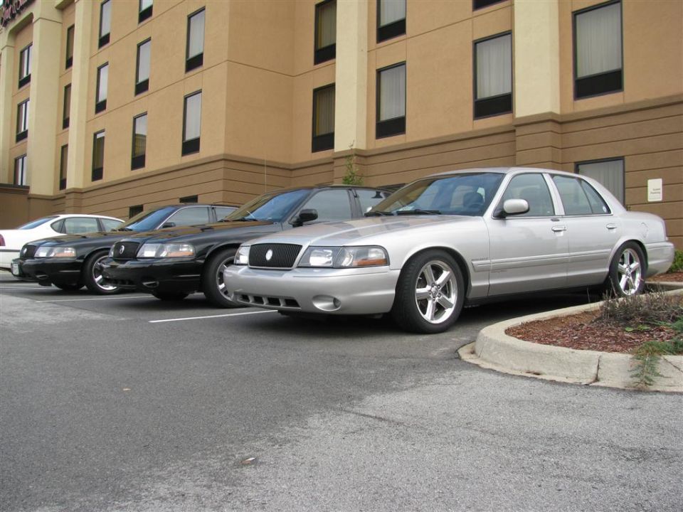 Silver and black sedans parked in front of a hotel