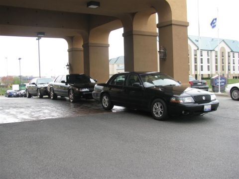 2003 Mercury Marauder - Several black sedans are lined up under a covered walkway at a hotel.
