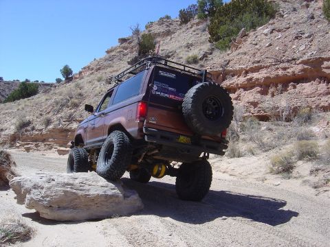 1986 Ford Bronco II - This modified 1986 Ford Bronco II navigates a rocky off-road course under a clear blue sky.
