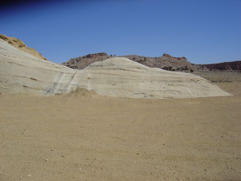 1986 Ford Bronco II - A vast desert scene unfolds with striking geological formations and a clear blue sky overhead.