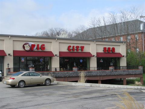 2003 Mercury Marauder - A gold coupe is parked in front of the Pig City BBQ restaurant.