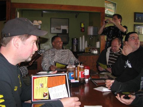 2003 Mercury Marauder - A group of men are seated at a table, engrossed in their menus during a gathering.