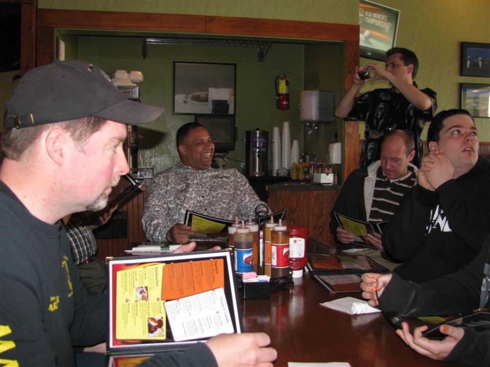 People gathered around a table, looking at menus