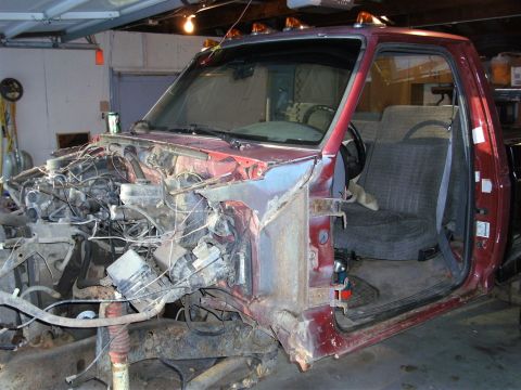 1994 Ford F-250 - This red pickup truck is in a state of disassembly, with its front end and engine compartment open.
