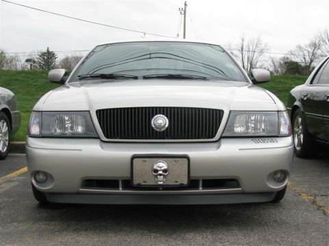 2003 Mercury Marauder - A silver sedan is parked in a lot, showing its front grille and custom license plate frame.