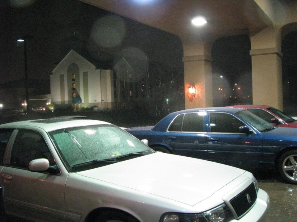 White and blue full-size sedans parked at night by a building with a steeple