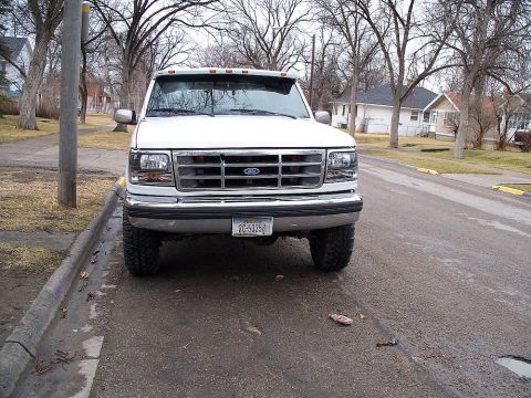 1992 Ford F-250 - This Ford F-250 pickup truck is shown from the front, parked on a street with houses in the background.