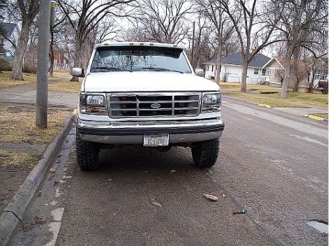 1992 Ford F-250 - This 1992 Ford F-250 is shown from the front on a street with houses in the background.