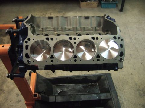 1971 Ford Mustang - A V8 engine block with pistons installed is mounted on an engine stand, ready for further assembly.