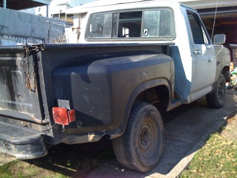 1985 Ford F-150 - This Ford F-150 pickup truck is seen from the rear quarter, showing its bed and passenger side.