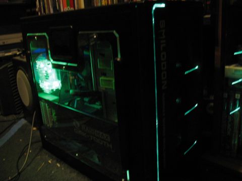 1997 Ford Crown Victoria - A custom-built computer case with internal green lighting and visible components, labeled 'SMILODON'.