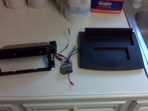 2008 Jeep Wrangler - Car stereo mounting kit and wiring harness laid out on a counter surface.