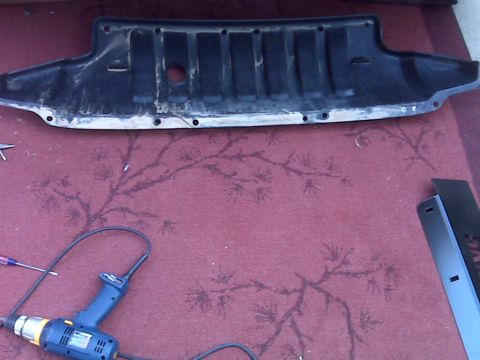 2008 Jeep Wrangler - Skid plate removed for installation, with tools laid out on the floor.