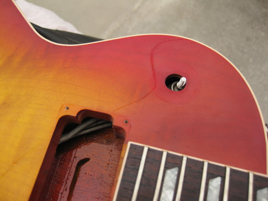 close-up of sunburst finish on guitar body, showing routing for electronics and fretboard