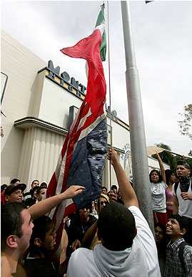 1973 Ford Torino - People are raising flags on a pole in front of a building.