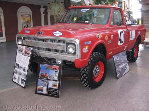 1990 Ford Bronco - red lifted vintage Chevrolet pickup numbered 40 with Goodyear and Cragar decals is displayed with informational placards.