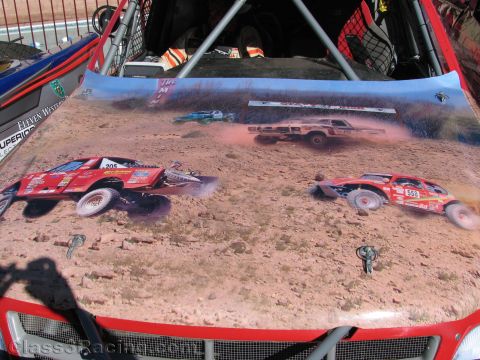 1990 Ford Bronco - vehicle hood airbrushed with a desert off-road racing scene showing red race cars, viewed from above with roll-cage tubing.