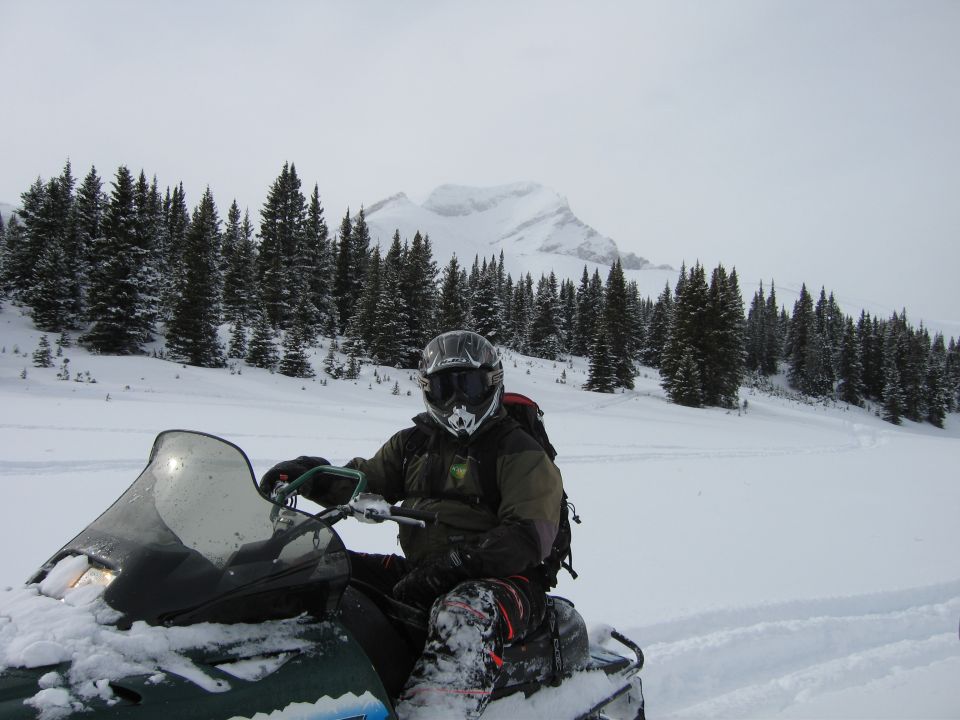 Snowmobile with rider in a snowy mountain landscape