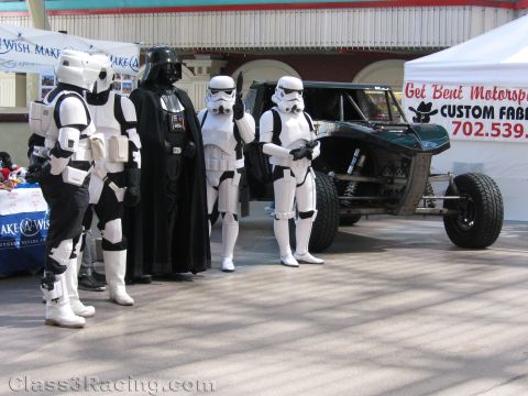 1990 Ford Bronco - Costumed Darth Vader and stormtroopers stand by a Make-A-Wish booth and a Get Bent Motorsports off-road buggy.