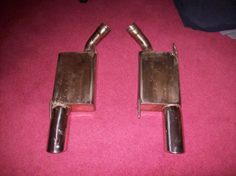 2007 Ford Mustang - A pair of aftermarket exhaust mufflers are displayed on a carpeted surface.