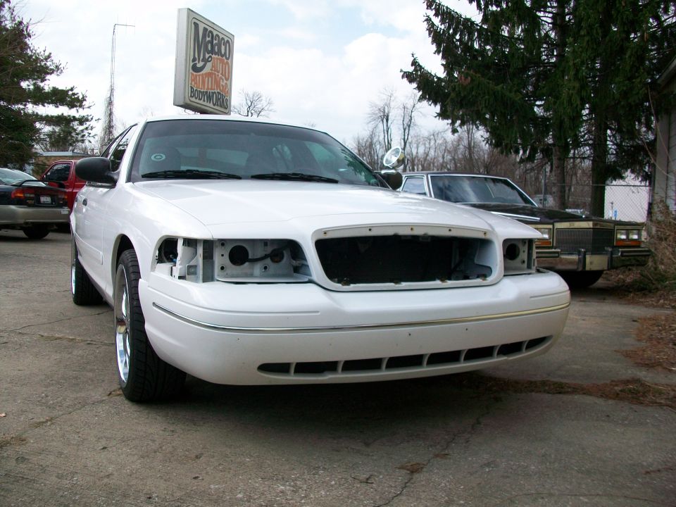 White 2003 Ford Crown Victoria front view, missing grille and headlights