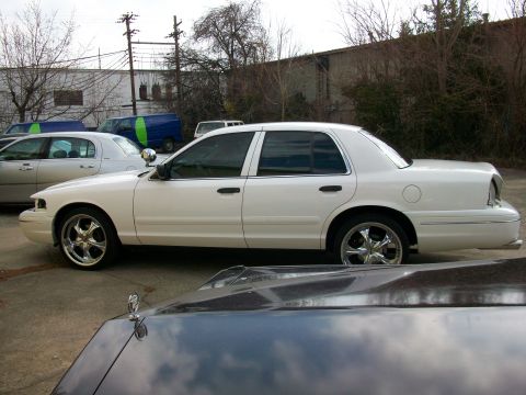 2003 Ford Crown Victoria - Side view of a white 2003 Ford Crown Victoria with chrome wheels.