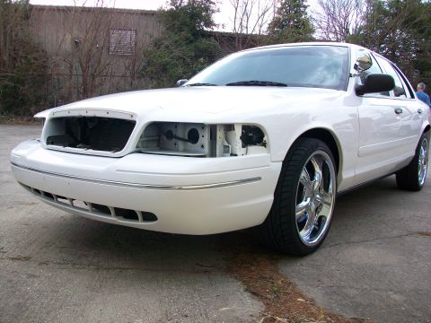 2003 Ford Crown Victoria - A white 2003 Ford Crown Victoria is shown from the front with its headlights and grille removed.
