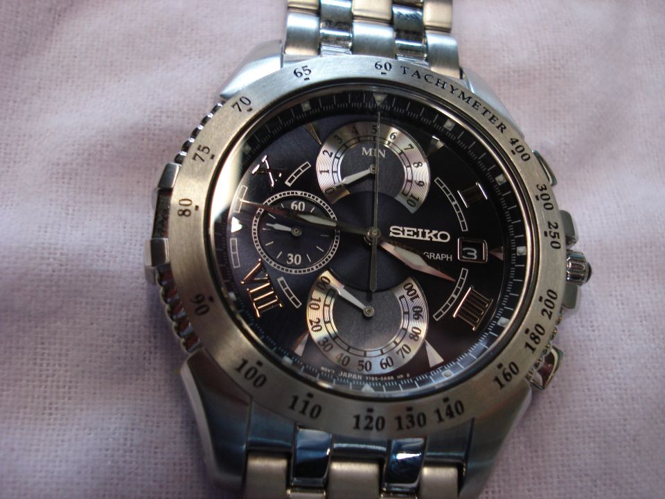 Silver Seiko chronograph watch with a black dial and tachymeter bezel