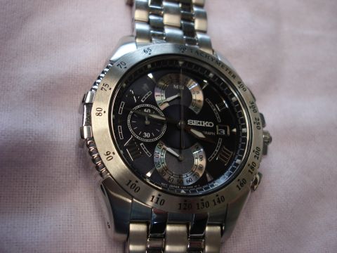 2000 Ford Crown Victoria - Close-up of a Seiko chronograph watch, a tachymeter bezel and multiple subdials on its black face.