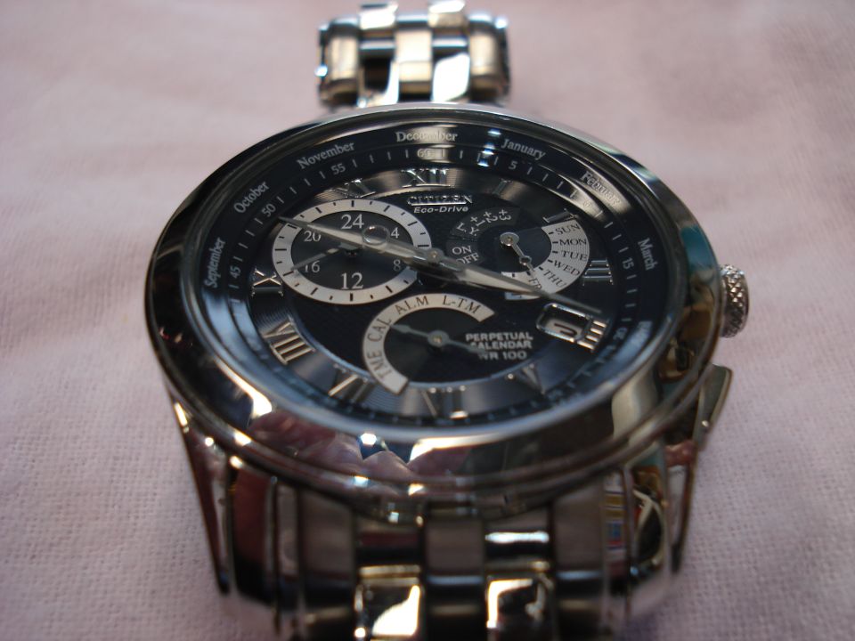 Close-up of a Citizen Eco-Drive Perpetual Calendar watch with a black face and silver band