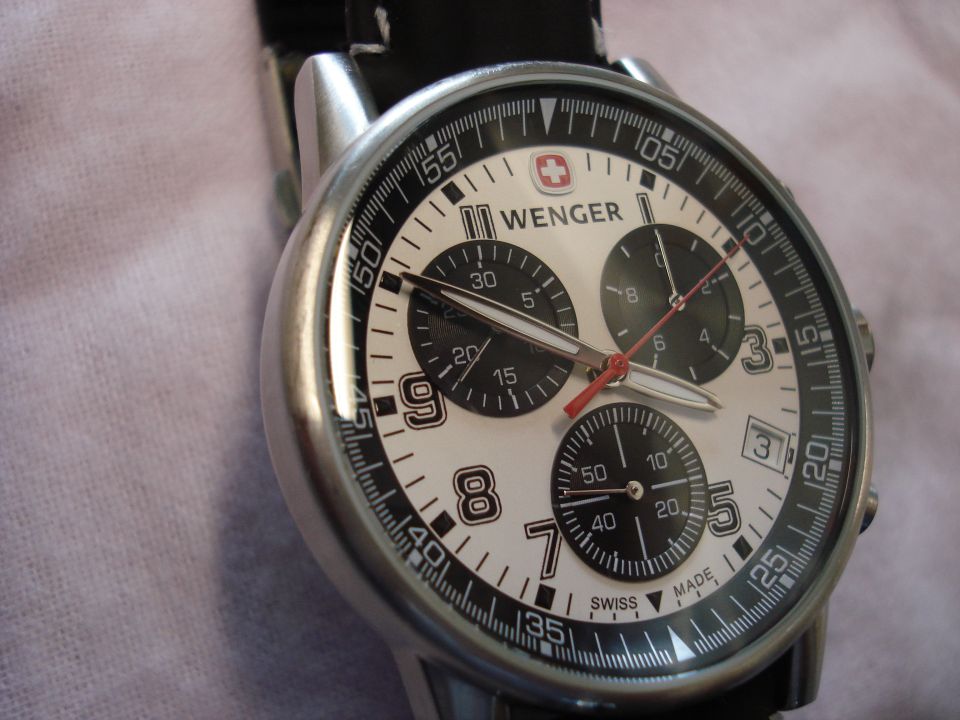 Watch with white face, black subdials, and silver case. "Wenger" logo visible