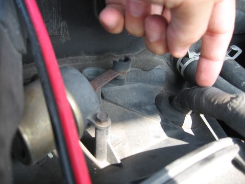 1994 Ford Bronco - Engine bay detail showing hoses and a metal lever mechanism.