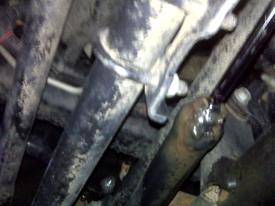 Close-up of a steering stabilizer assembly with metal rods and brackets